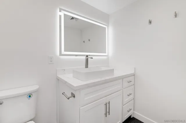a bathroom with a sink toilet and mirror