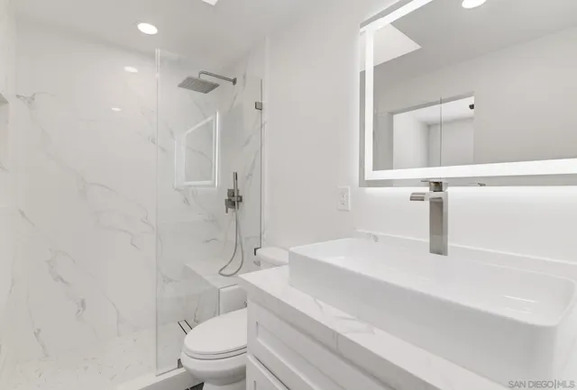 a bathroom with a sink a toilet and shower