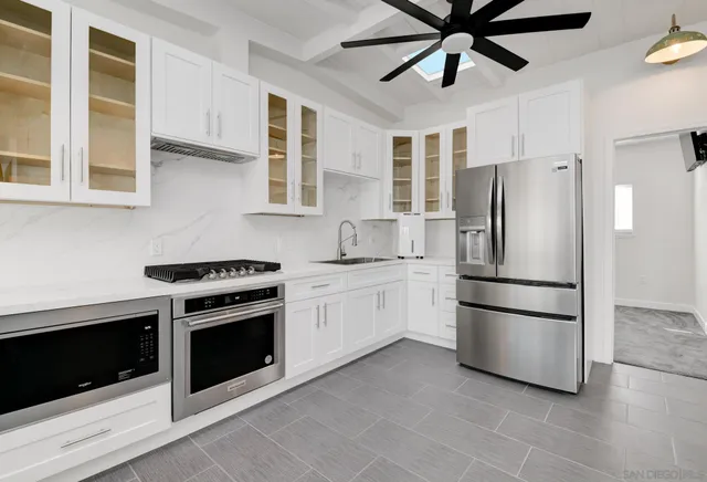 a kitchen with stainless steel appliances granite countertop a refrigerator a stove a sink and a refrigerator