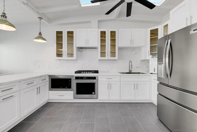 a kitchen with stainless steel appliances granite countertop a stove a sink and a refrigerator