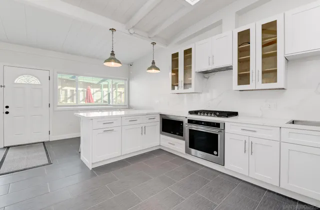 a kitchen with white cabinets and white appliances