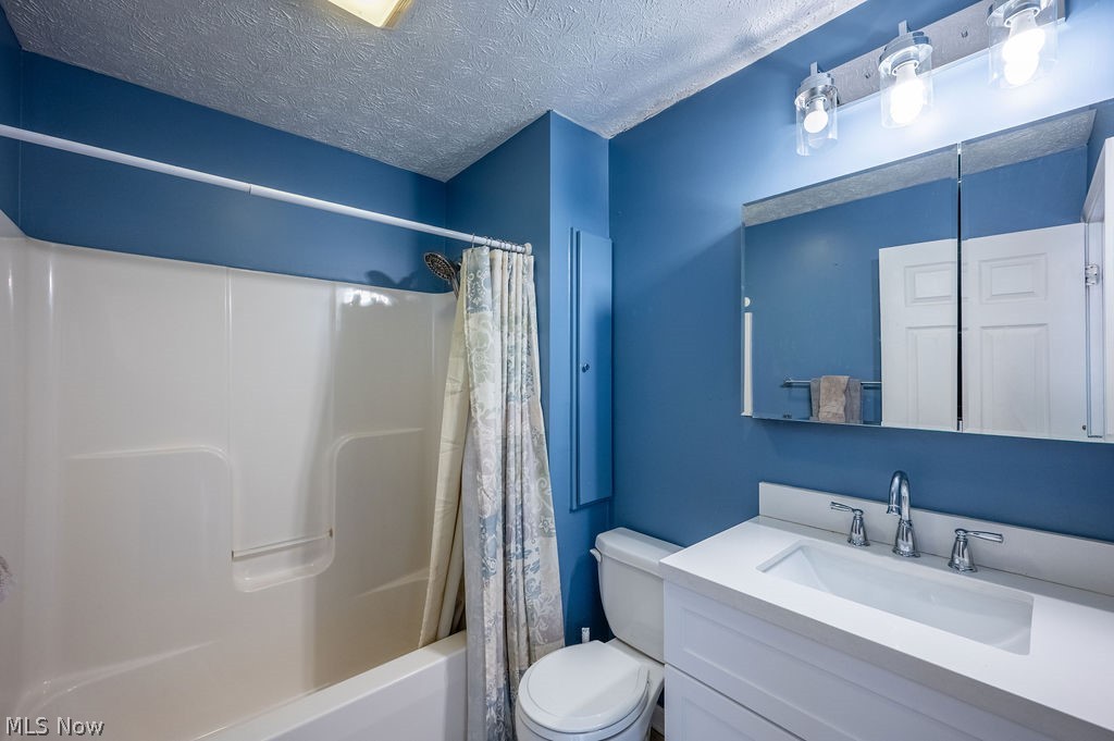 3601 River Road Vienna, WV 26105 - Photo 24 of 40 Bathroom with vanity, a textured ceiling, and shower / tub combo