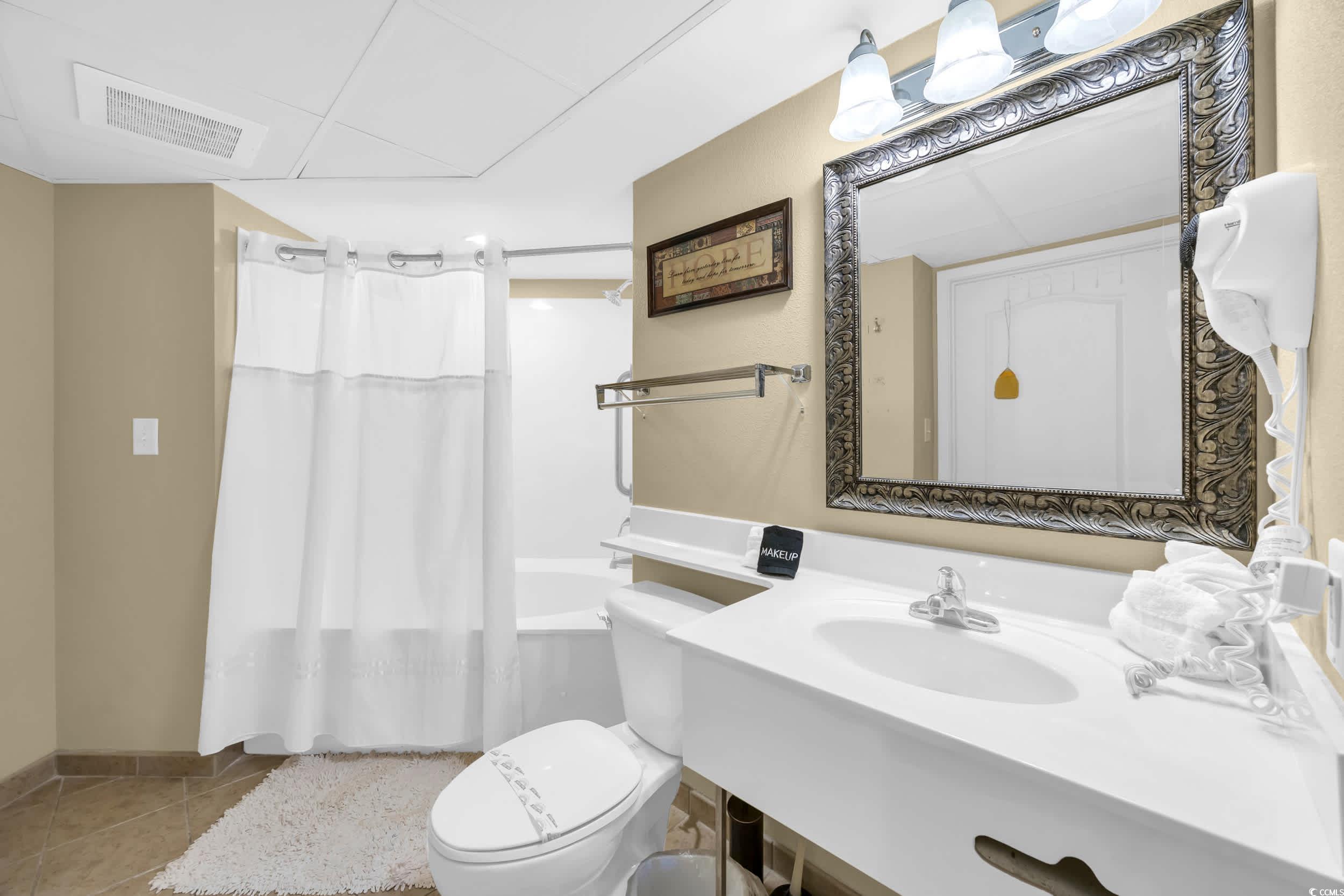 2504 North Ocean Boulevard, Unit 1234 Myrtle Beach, SC 29577 - Photo 13 of 22 Full bathroom featuring shower / tub combo with curtain and tile patterned floors