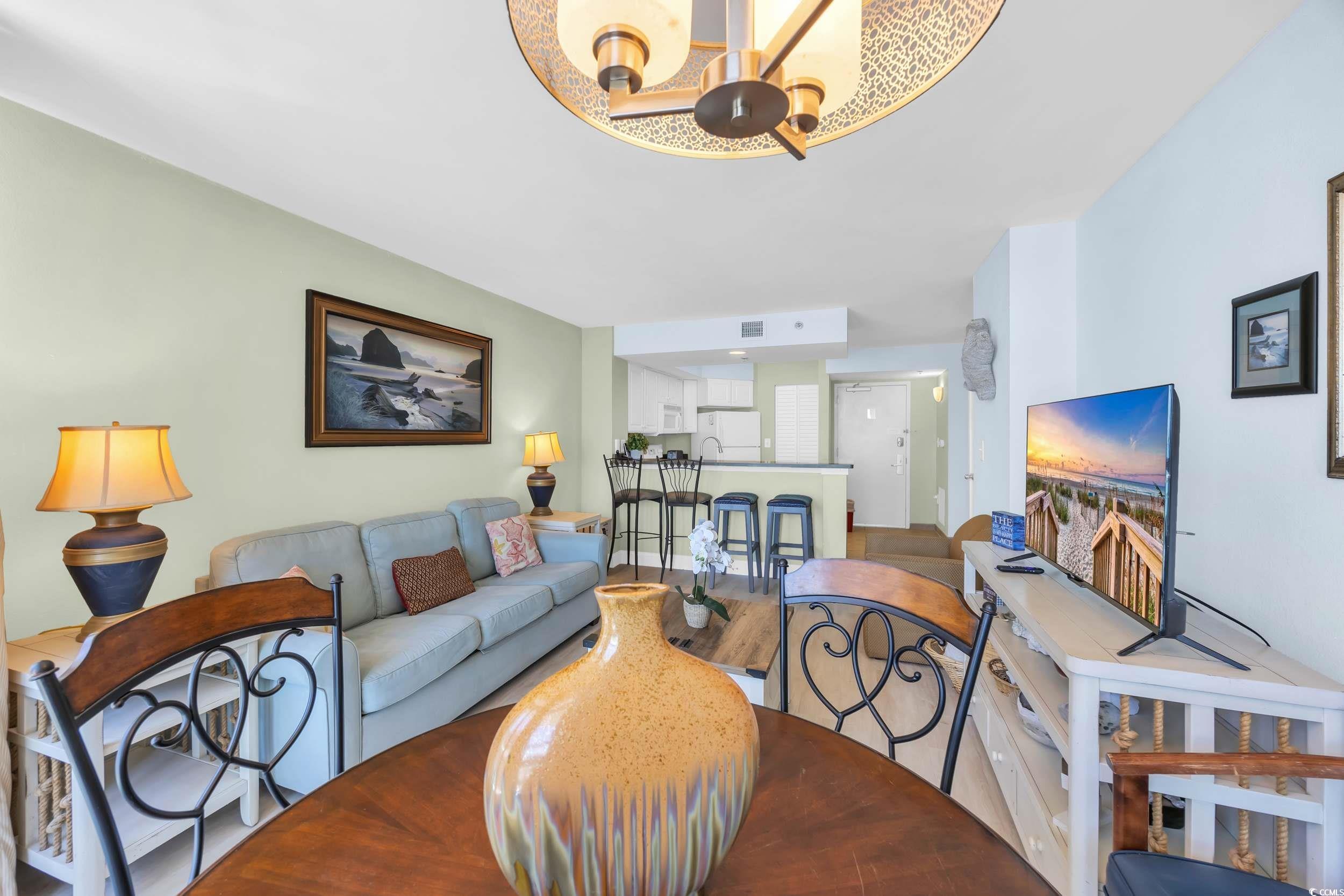 2504 North Ocean Boulevard, Unit 1234 Myrtle Beach, SC 29577 - Photo 4 of 22 Living area featuring wood finished floors and a chandelier