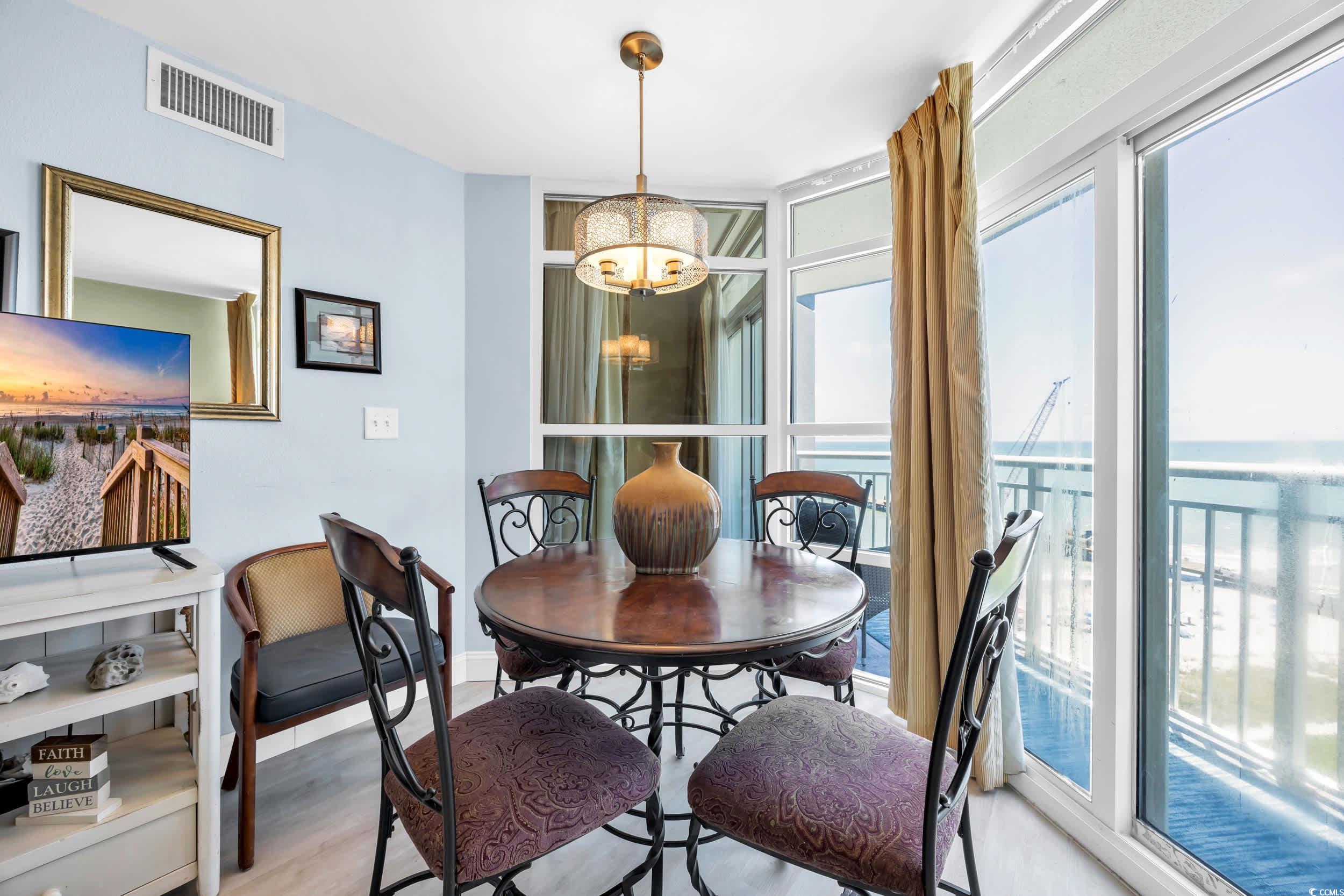 2504 North Ocean Boulevard, Unit 1234 Myrtle Beach, SC 29577 - Photo 5 of 22 Dining space featuring floor to ceiling windows, a chandelier, wood finished floors, and a water view