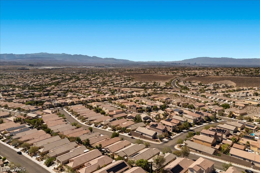 2627 Dirleton Place Henderson, NV 89044 - Photo 40 of 42 An aerial panorama reveals a vast residential community nestled against a majestic mountain backdrop.