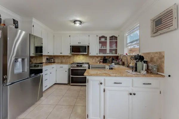 a kitchen with granite countertop white cabinets and white appliances