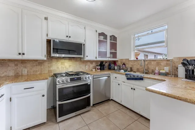 a kitchen with stainless steel appliances granite countertop a refrigerator and a stove