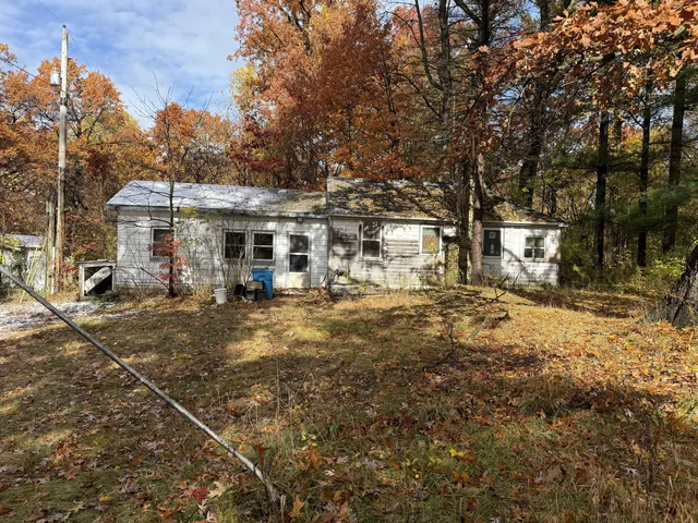 a view of a large white house with a large tree in front of it