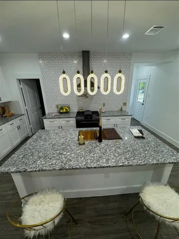 a bathroom with a granite countertop sink a toilet and a mirror