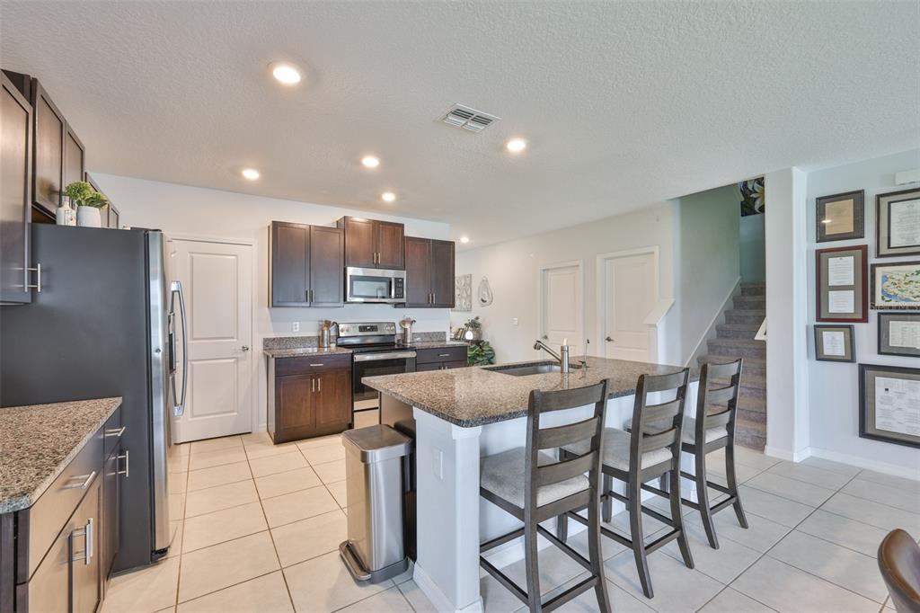 12746 Weston Oaks Lane Riverview, FL 33579 - Photo 11 of 56 a kitchen with a sink a counter top space cabinets and stainless steel appliances
