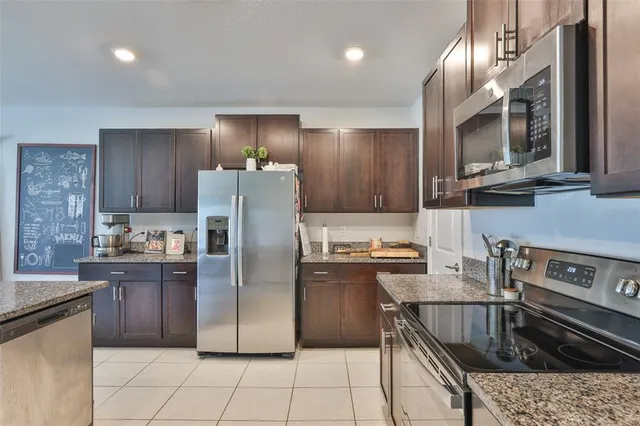 a kitchen with stainless steel appliances granite countertop a sink counter space cabinets and a view of kitchen