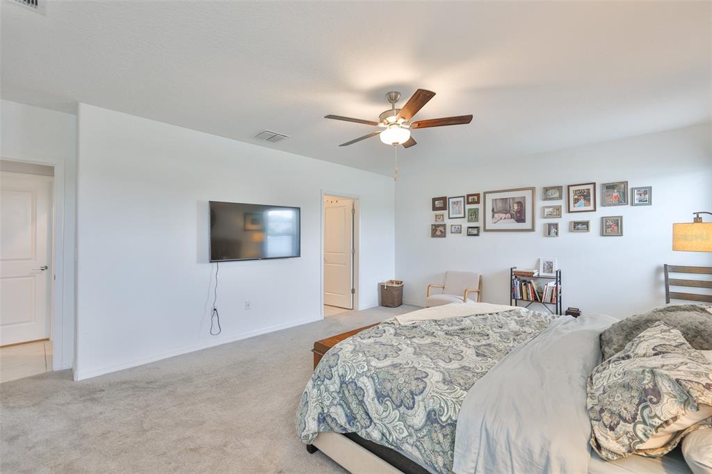 12746 Weston Oaks Lane Riverview, FL 33579 - Photo 24 of 56 a bedroom with a large bed and a tv