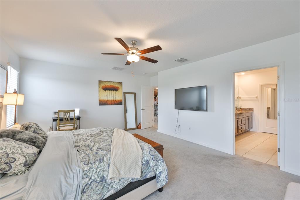12746 Weston Oaks Lane Riverview, FL 33579 - Photo 25 of 56 a bedroom with a large bed and a flat screen tv