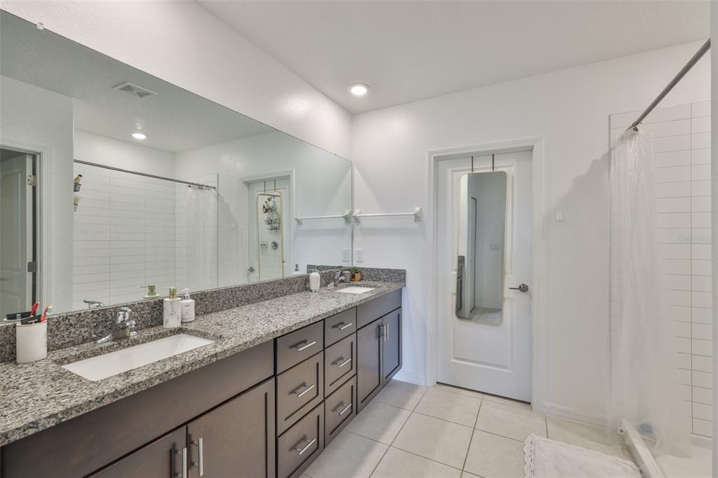 12746 Weston Oaks Lane Riverview, FL 33579 - Photo 26 of 56 a spacious bathroom with a granite countertop sink a mirror and a shower