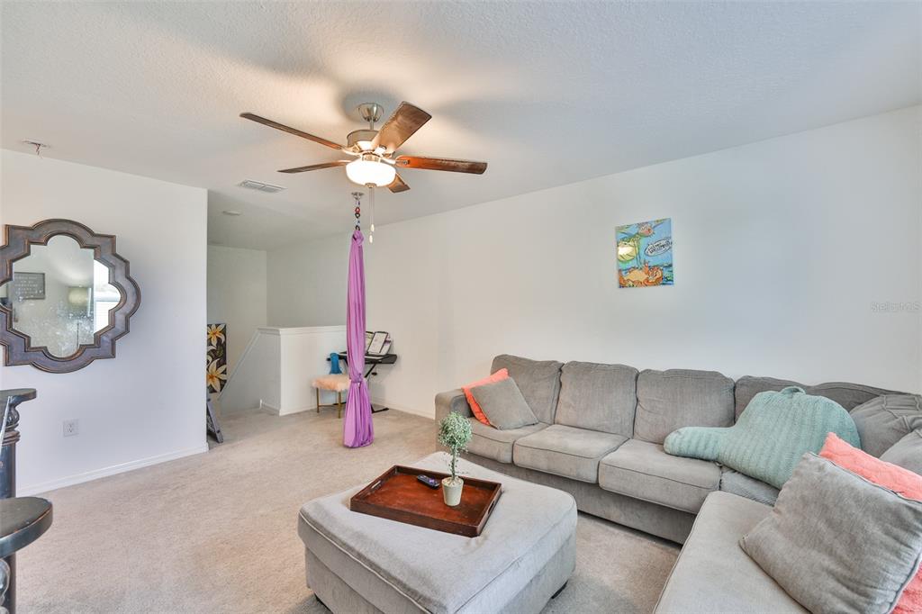 12746 Weston Oaks Lane Riverview, FL 33579 - Photo 29 of 56 a living room with furniture and a chandelier