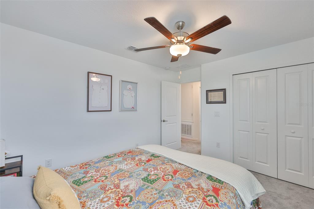 12746 Weston Oaks Lane Riverview, FL 33579 - Photo 32 of 56 a bedroom with a large bed and a chandelier