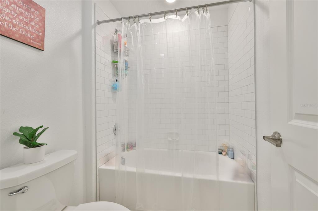 12746 Weston Oaks Lane Riverview, FL 33579 - Photo 37 of 56 a bathroom with a shower curtain a bathtub and a shower