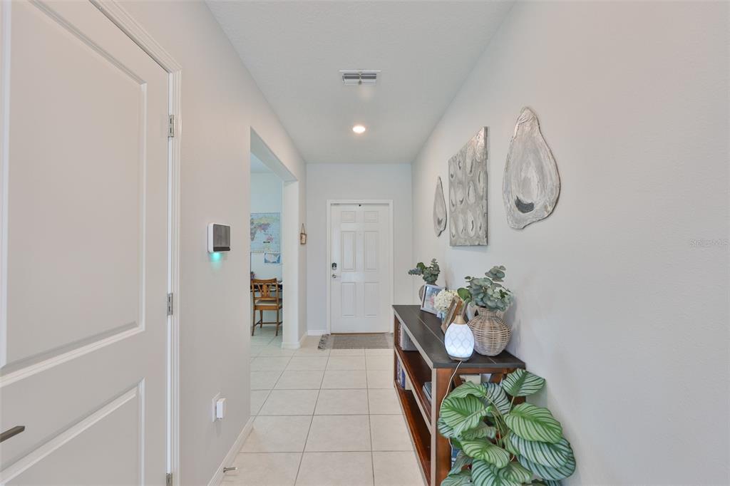 12746 Weston Oaks Lane Riverview, FL 33579 - Photo 4 of 56 a hallway with painting and flowers