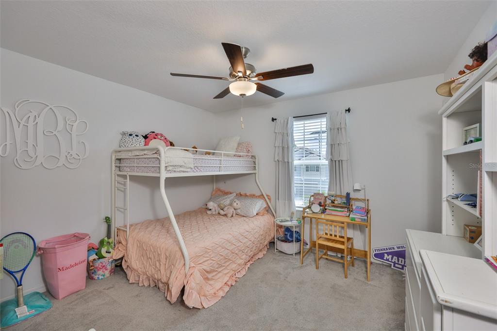 12746 Weston Oaks Lane Riverview, FL 33579 - Photo 41 of 56 a bedroom with a bed and a table in it