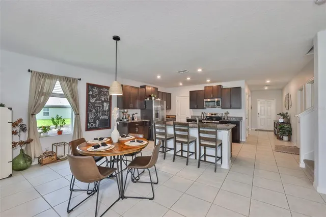 a dining room filled with furniture and a large window