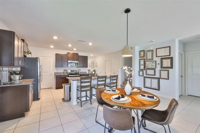 a kitchen with a dining table chairs and kitchen view