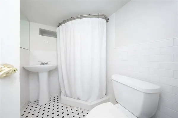 a bathroom with a sink a toilet a shower and a mirror