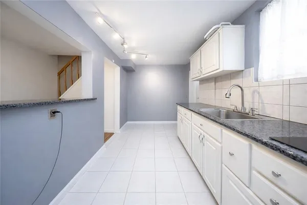 a large white kitchen with granite countertop a sink