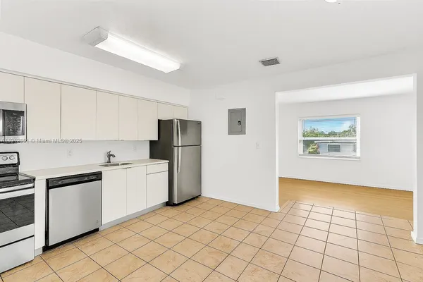 a kitchen with granite countertop a refrigerator and a stove top oven