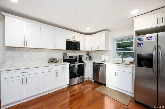 a kitchen with cabinets stainless steel appliances and a window