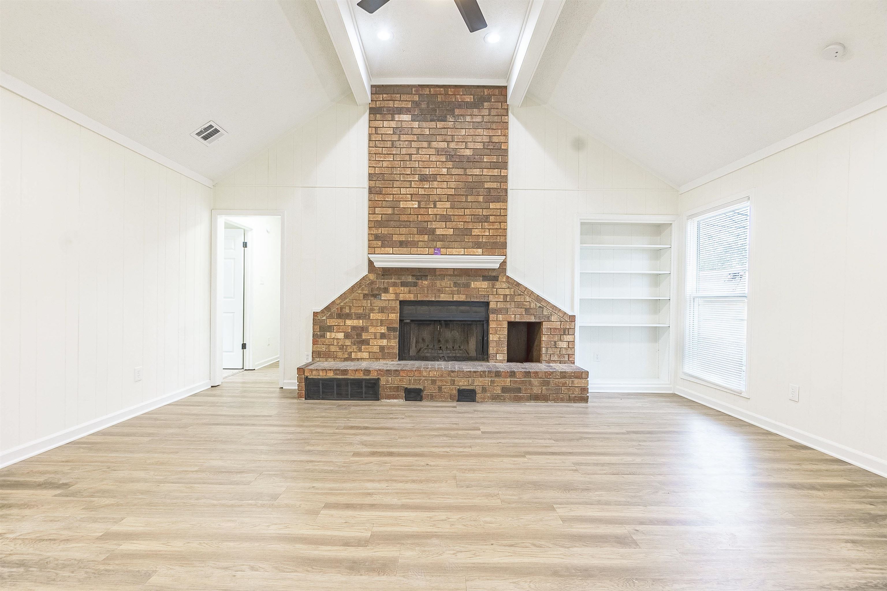 6538 Castle Ridge Cove Memphis, TN 38141 - Photo 4 of 27 Unfurnished living room with vaulted ceiling with beams, built in features, and light hardwood / wood-style flooring