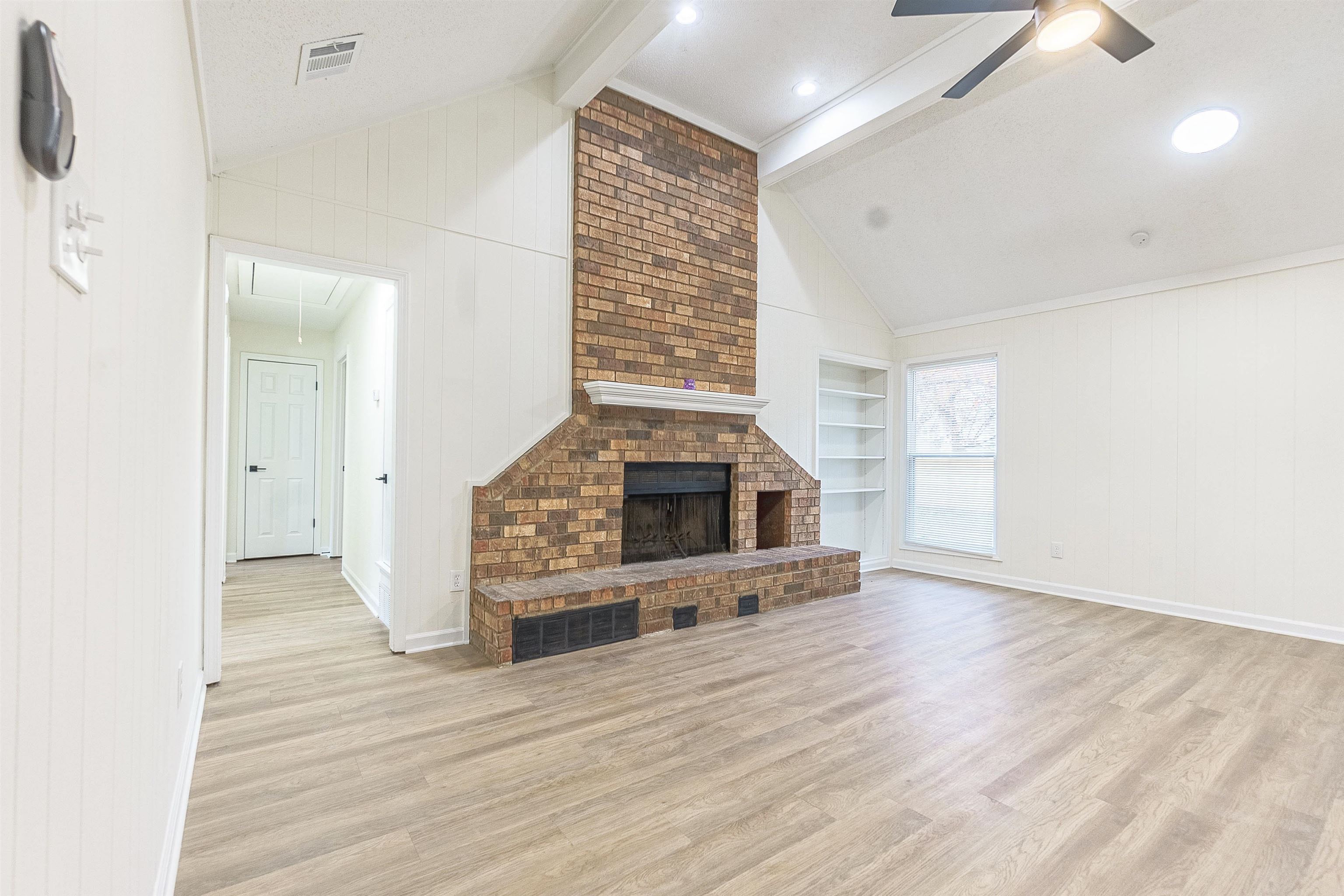 6538 Castle Ridge Cove Memphis, TN 38141 - Photo 5 of 27 Unfurnished living room with built in shelves, ceiling fan, light hardwood / wood-style floors, and vaulted ceiling with beams