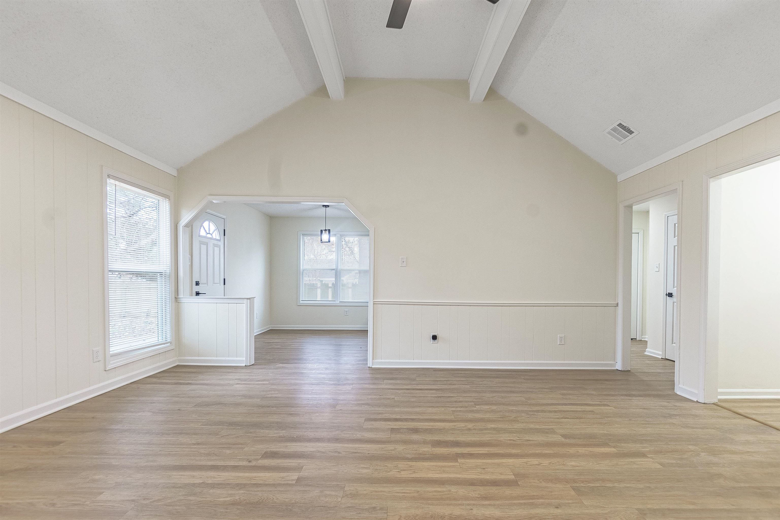 6538 Castle Ridge Cove Memphis, TN 38141 - Photo 7 of 27 Unfurnished living room featuring vaulted ceiling with beams, a wealth of natural light, ceiling fan, and light hardwood / wood-style floors