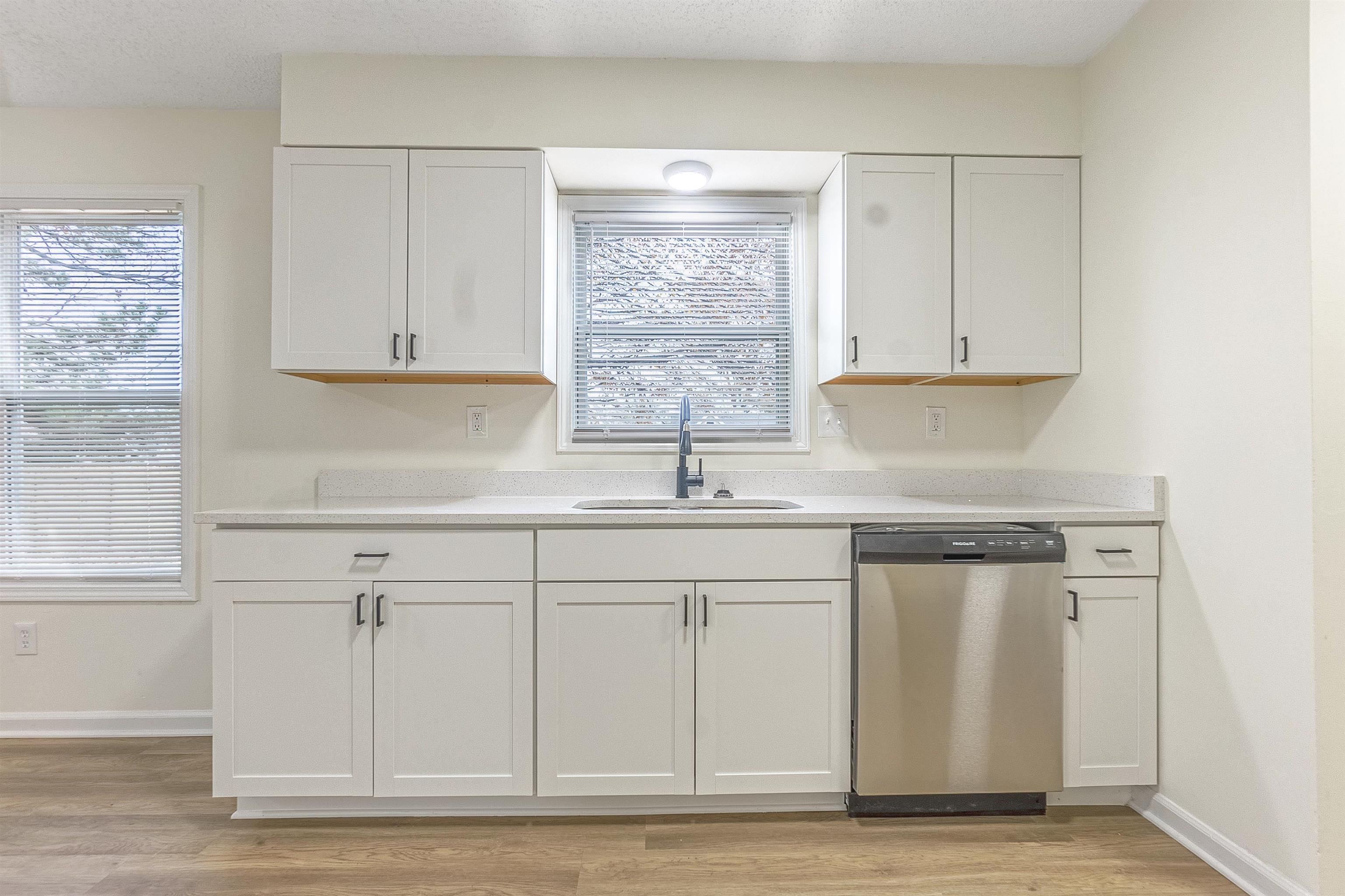 6538 Castle Ridge Cove Memphis, TN 38141 - Photo 10 of 27 Kitchen with white cabinets, light wood-type flooring, stainless steel dishwasher, and sink