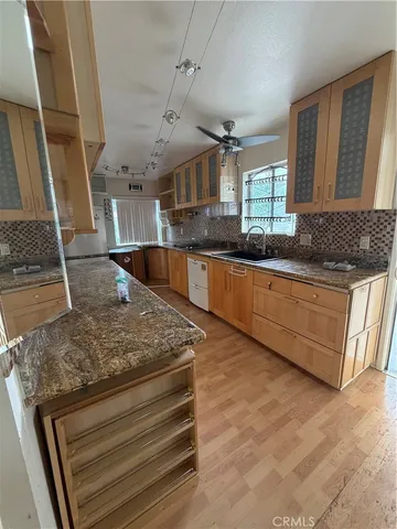 a kitchen with stainless steel appliances granite countertop a sink stove and cabinets