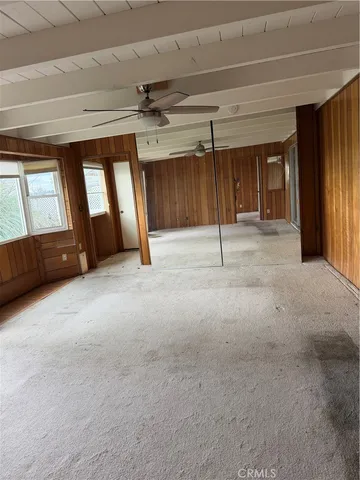 a view of an empty room with a fireplace and a window