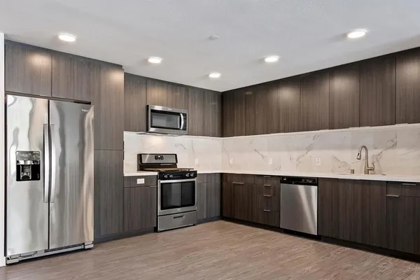 a kitchen with stainless steel appliances granite countertop a sink and a refrigerator