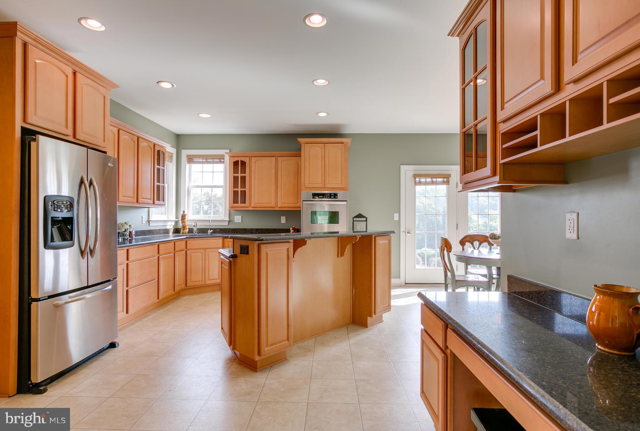 4628 Dave Rill Road Hampstead, MD 21074 - Photo 15 of 30 a kitchen with stainless steel appliances granite countertop a refrigerator a stove and a sink with wooden floors