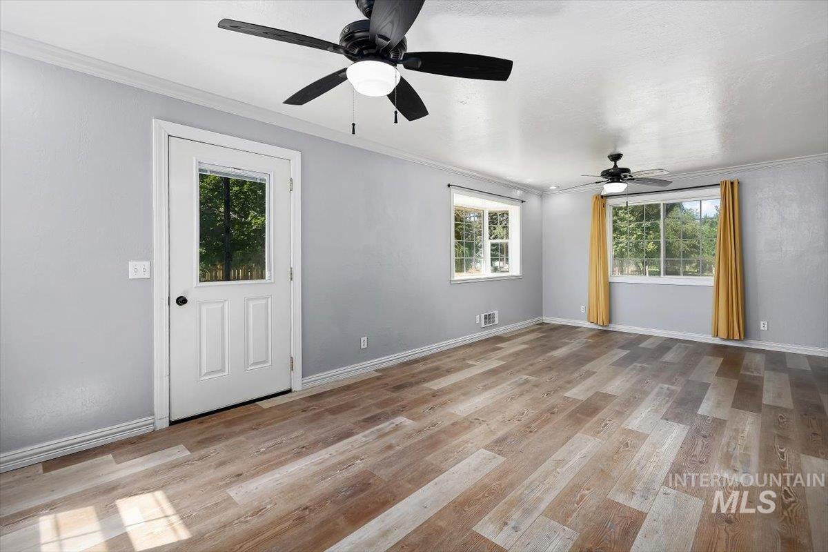 1940 Q Street Heyburn, ID 83336 - Photo 9 of 30 Spacious room featuring wood-finish flooring, light gray walls, and white trim