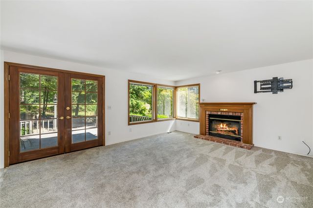 a view of an empty room with a fireplace and a window