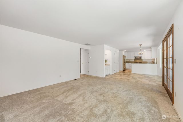 a view of a kitchen with refrigerator and white cabinets