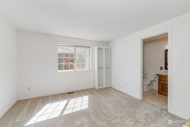 a view of an empty room with a window and a bathroom