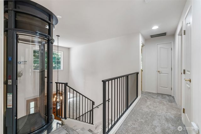 a view of a hallway with wooden floor and staircase