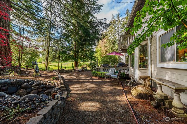 a backyard of a house with barbeque oven table and chairs