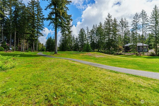 a view of a big yard with trees in the background