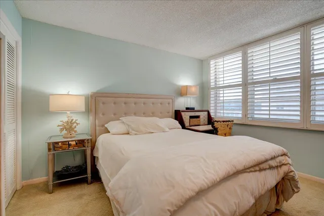 a bedroom with a bed and a large window