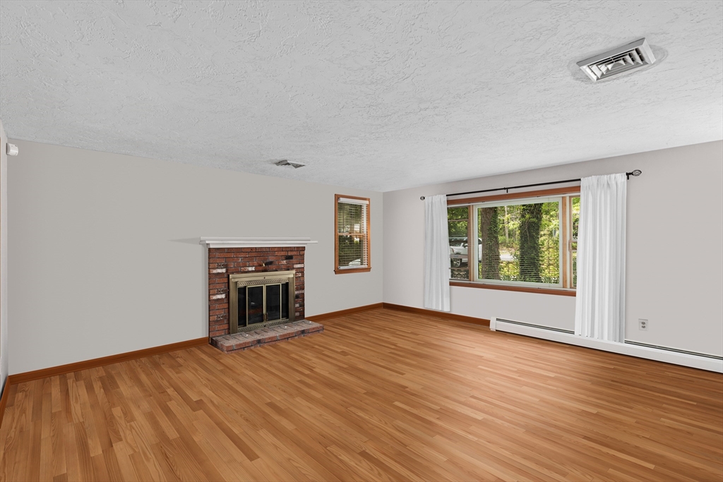 34 Diandy Road Bourne, MA 02562 - Photo 8 of 20 a view of empty room with wooden floor and fireplace