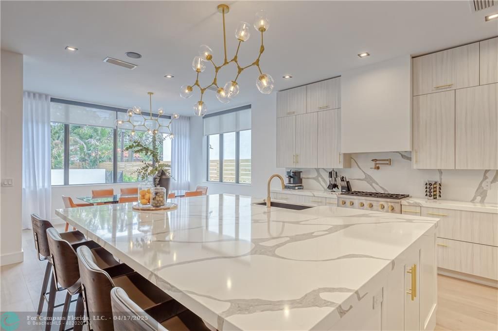 2929 Center Avenue Fort Lauderdale, FL 33308 - Photo 18 of 35 a kitchen with kitchen island granite countertop a sink a stove a dining table and chairs
