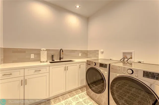 a utility room with sink dryer and washer