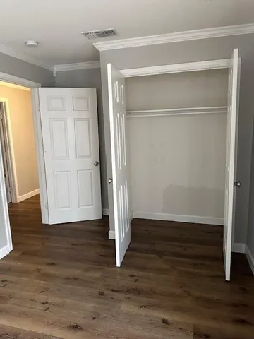 an empty room with wooden floor and entrance